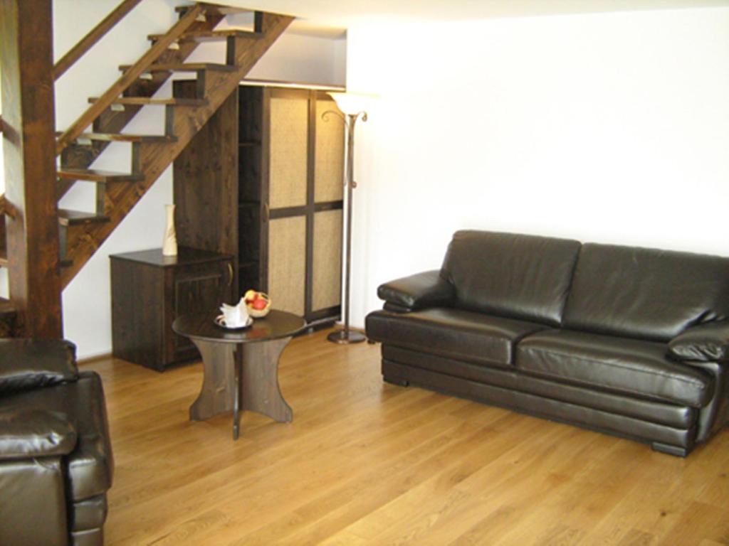 Bright living room with leather sofas and staircase